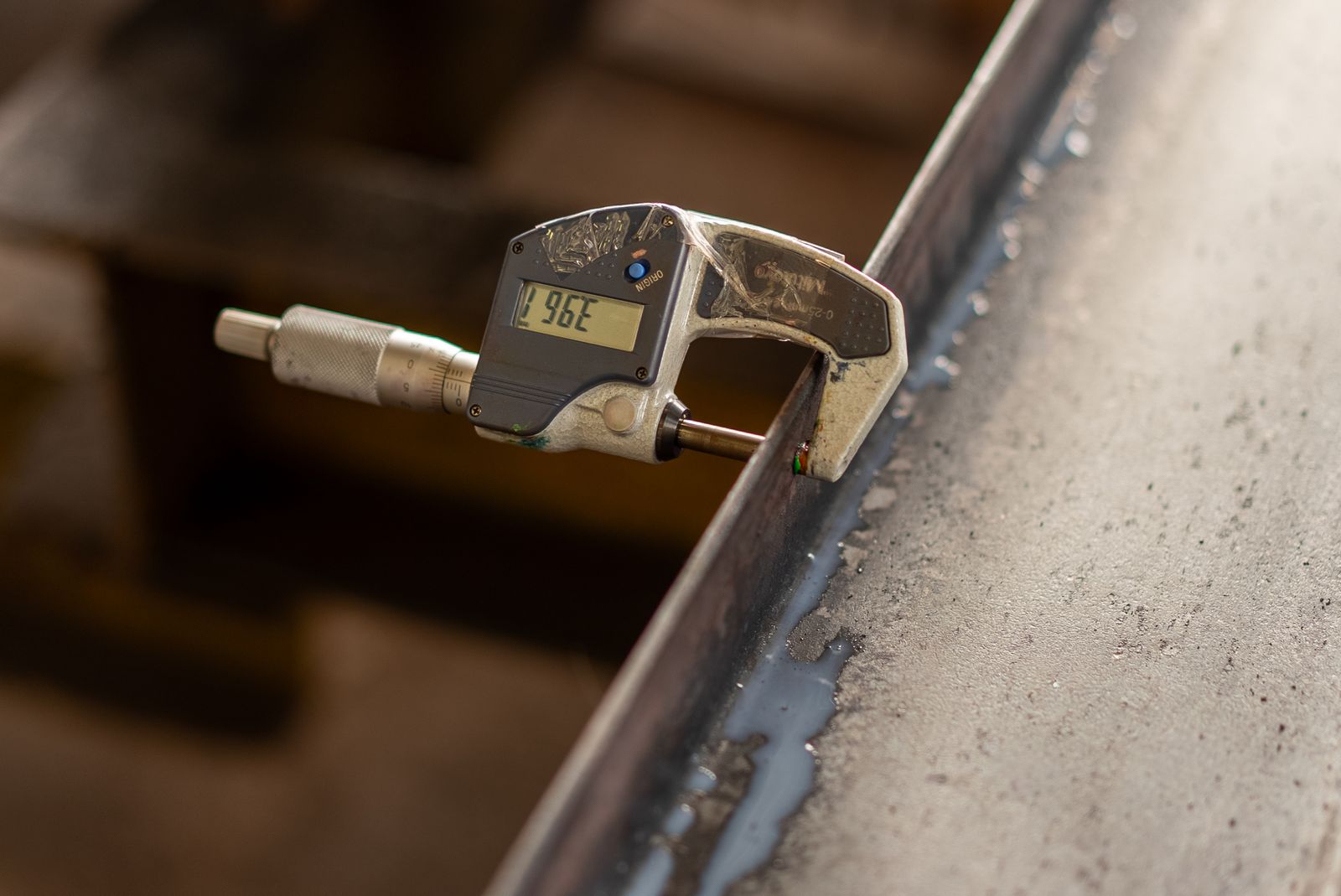Digital caliper measuring a metal surface